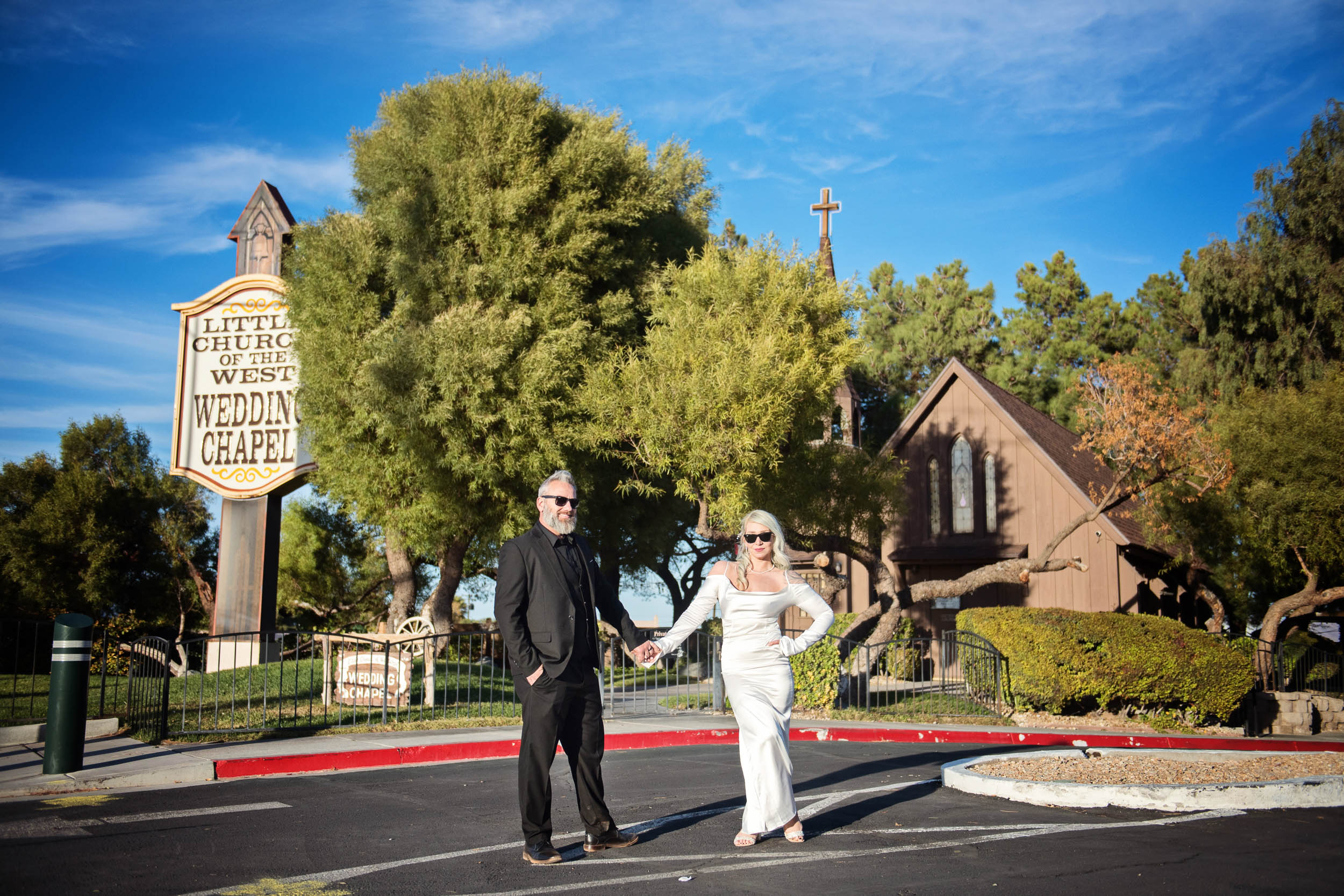 Bride and groom hold hands outside Little Church Of the West, Las Vegas street. 
