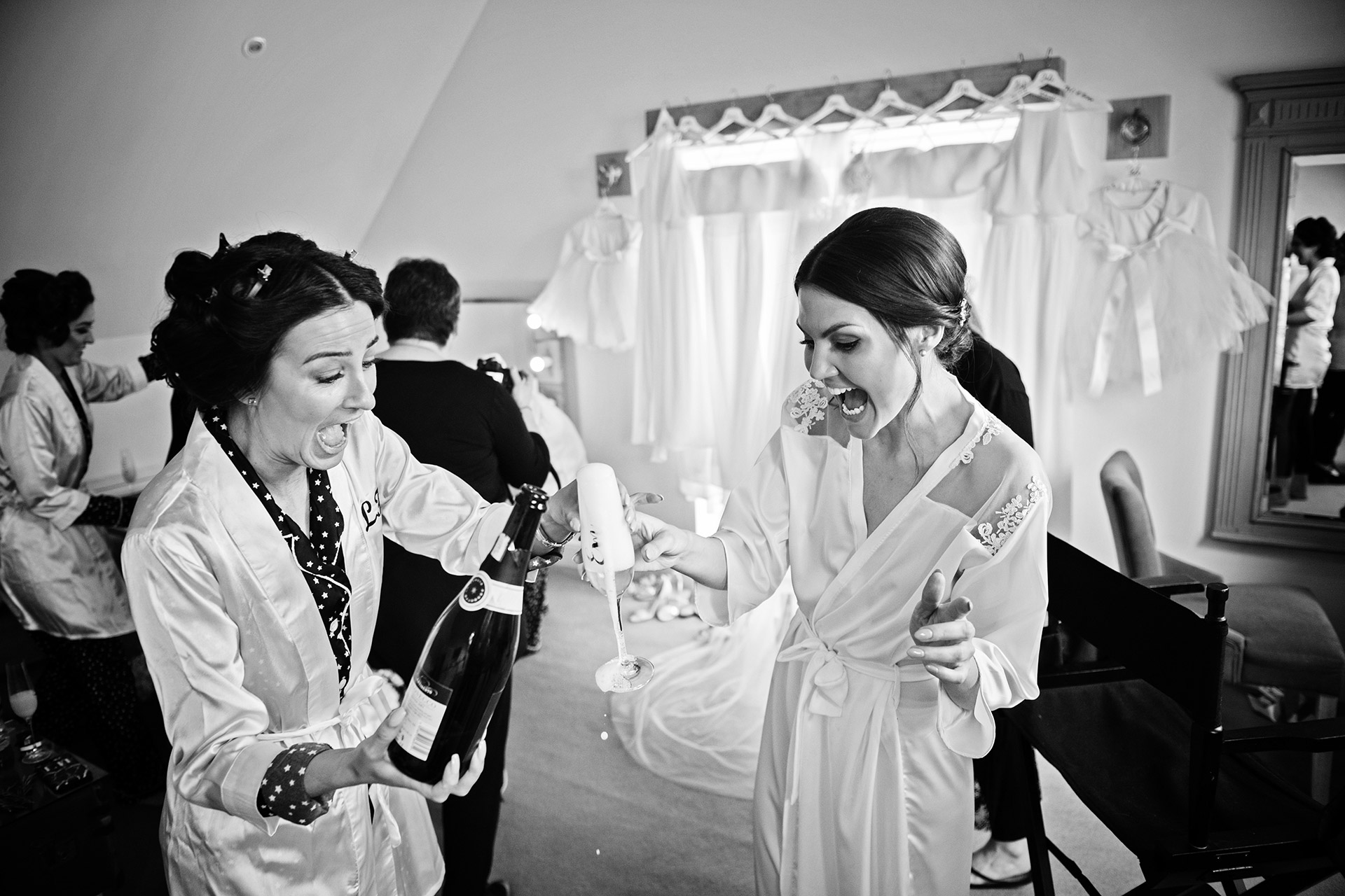 bride and bridesmaid spilling champagne