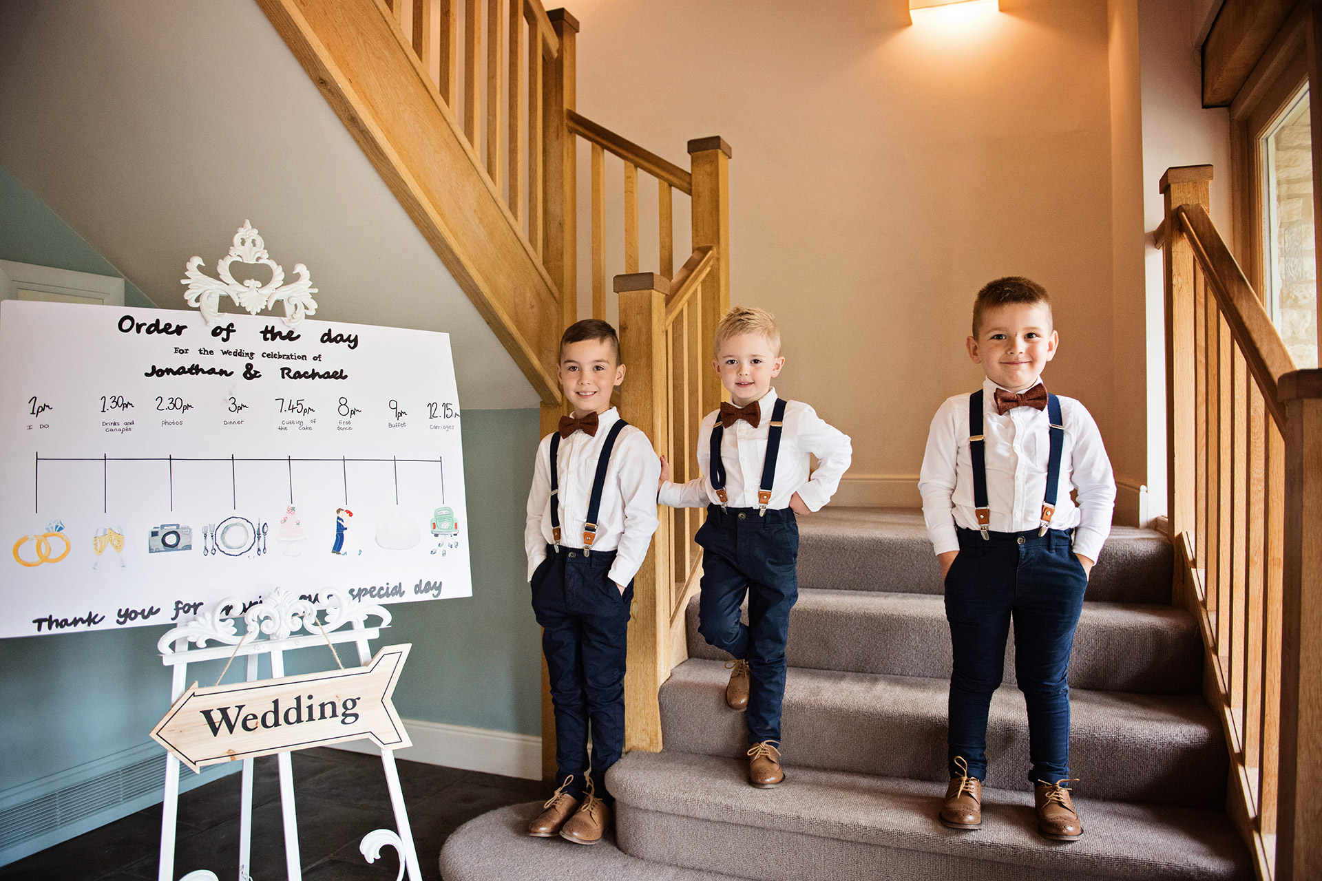 Page boys welcoming with cheeky smiles and dapper clothes