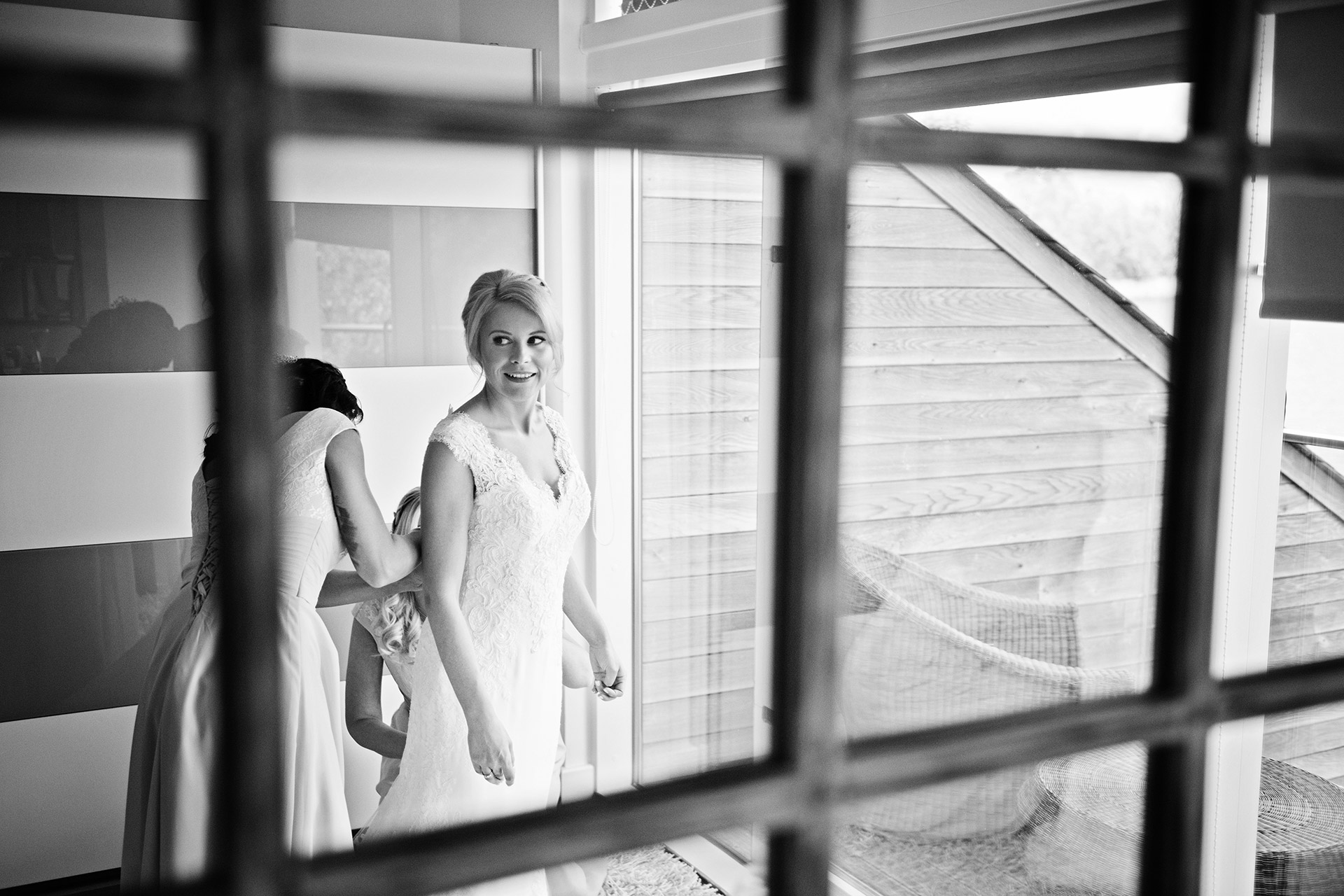 bride getting into her wedding dress, photograph looking through a mirror. 