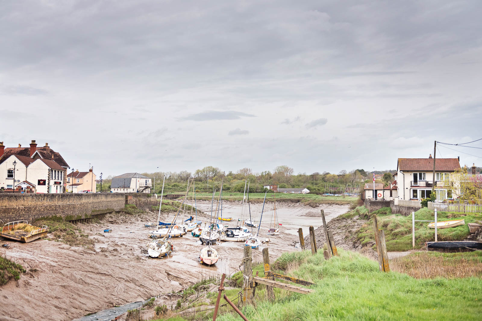 Photo of the village of Pil. With the tide receded, small boats sit awkwardly on the silt riverbank 