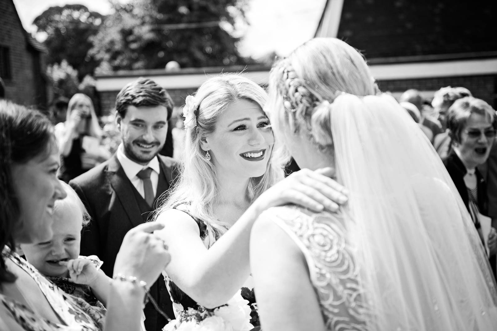 A b&w image of a friend greeting the bride.