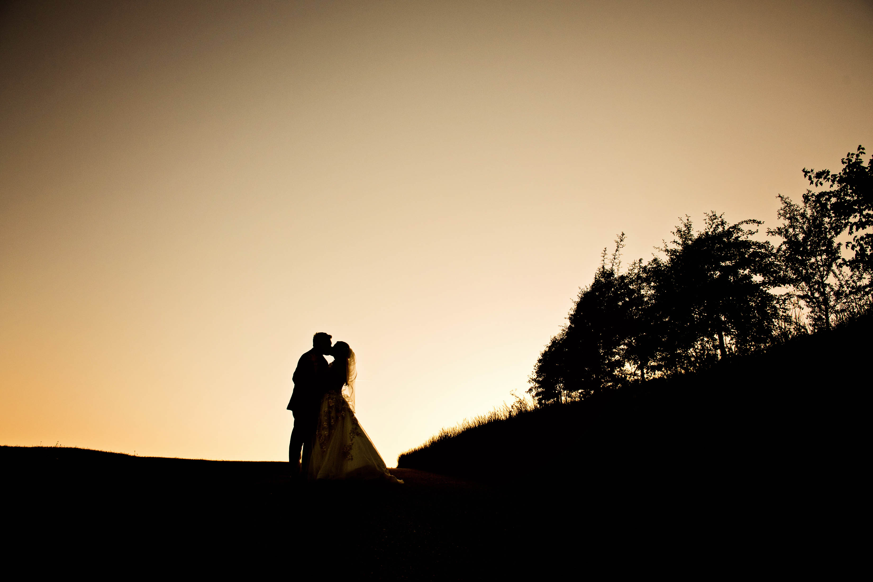 Silhouette of bride and groom with sunset behind them