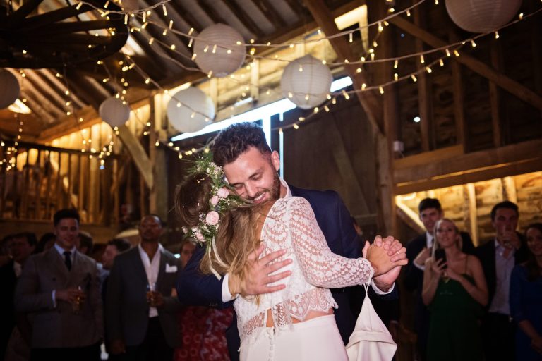 Groom hugging his wife during their first dance at their wedding at Over Barn, photo by Blooming Photography