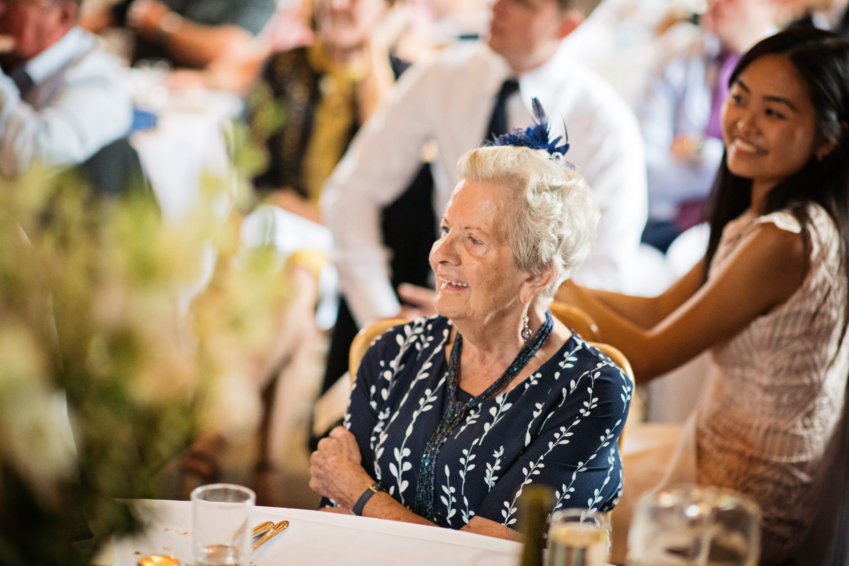 Candid photo of a wedding guest smiling at a speech.