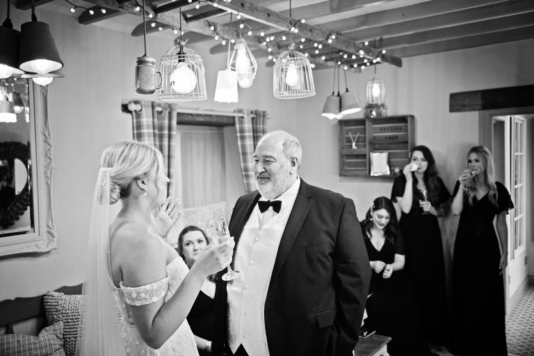 B& w image of the father of the bride seeing his daughter (bride) for the first time. In the bridal suite at Blackwell Grange.