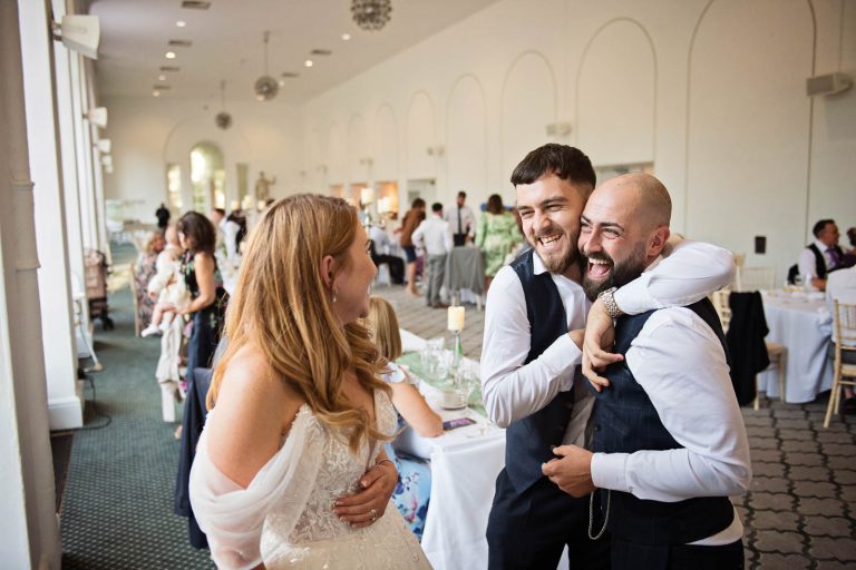 Natural photo of the groom being hugged by his friend.