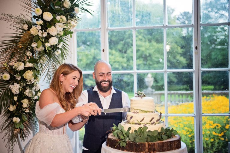 Photo of bride and groom cutting their wedding cake.