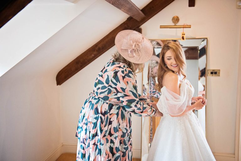 Storytelling photo of bride putting on her wedding dress.