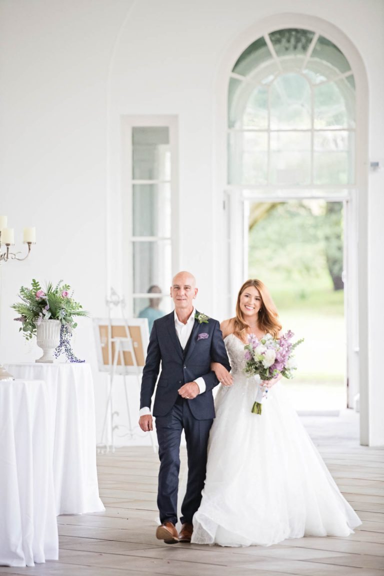Elegant portrait photo of a bride and her dad walking down the wedding isle at Margam Country Park.