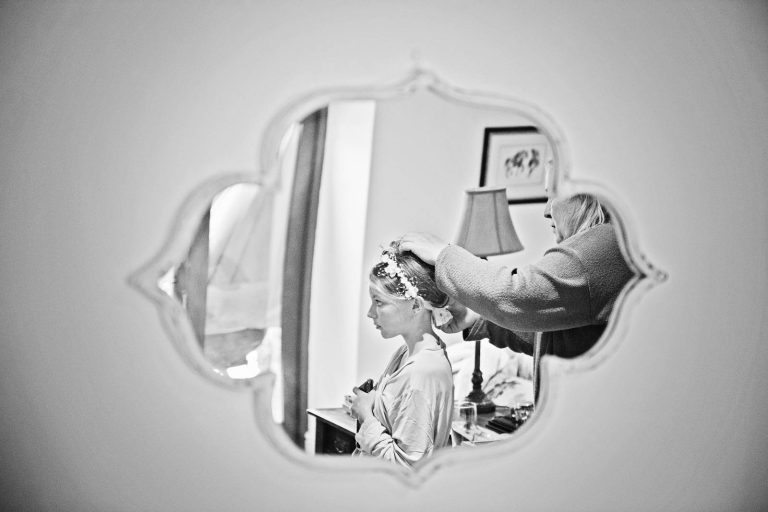 B&W Storytelling photo of bridesmaid reflective in mirror by Cardiff wedding photographer, Blooming Photography