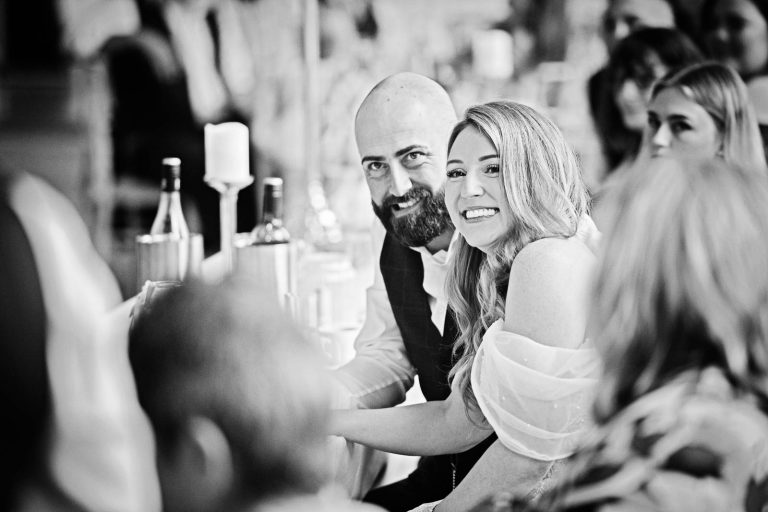 Natural b&w image of the bride and groom taken during the wedding speeches.