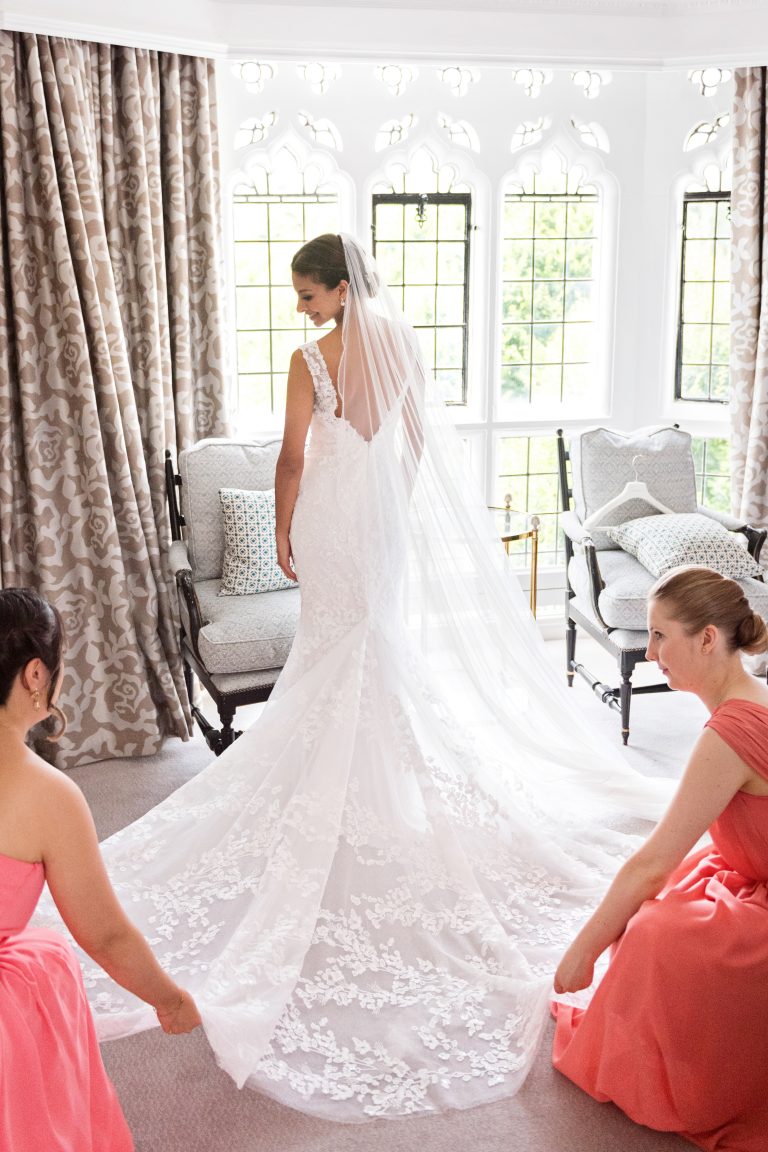 Bridesmaids lay the brides wedding dress out. Bride looking over her shoulder. Gorgeous.