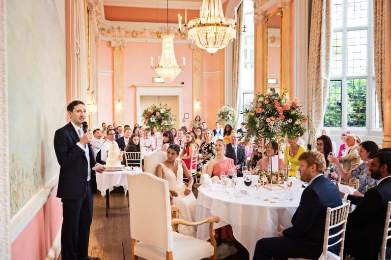 Groom saying his wedding speech, wide view with all the guests watching. Photographed in Danesfield House Ballroom. Photograph by Ben Roberts, Blooming Photography.