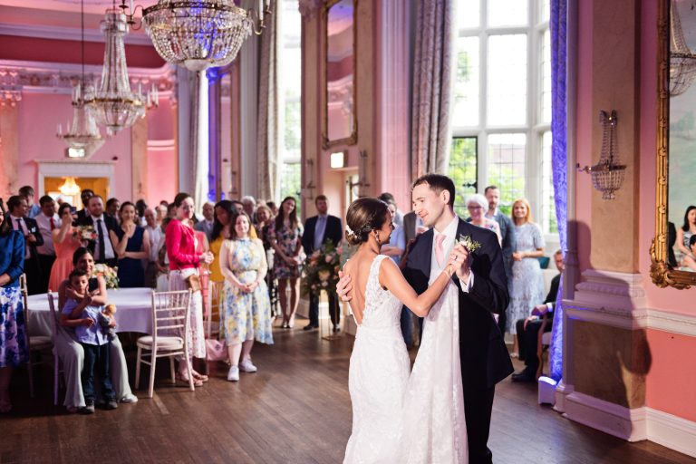 Bride and groom do their first dance. Photographed in the elegant Danesfield House Hotel and Spa Ballroom.