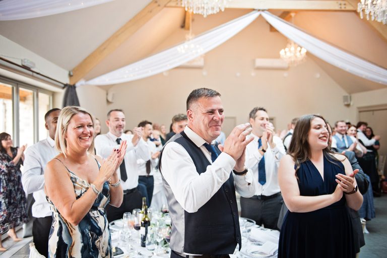 Wedding guests clap and cheer with the announcement of the bride and groom to the wedding breakfast. Photo by Blooming Photography. Taken at Blackwell Grange, Warwickshire.