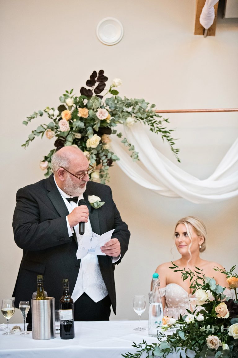 Father of the bride delivering his speech with the bride next to him. Candid photo by Blooming Photography. Taken at Blackwell Grange, Warwickshire.