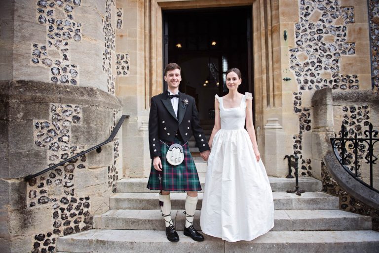 Bride and groom outside Winchester registry office. before their wedding. Candid photo by Blooming Photography.