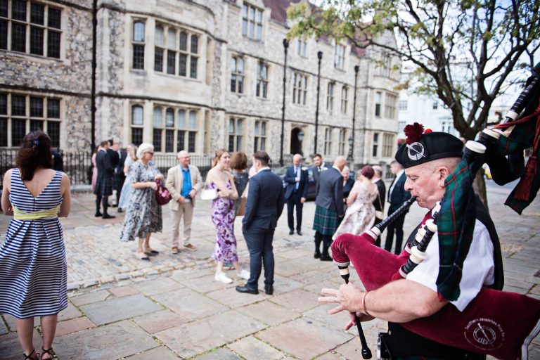 Candid moments, bagpipe player outside Winchester Registry Office, Photo by Blooming Photography