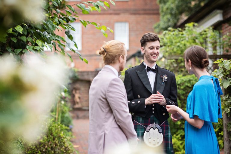 Natural wedding photo of guests talking to groom at Hotel Du Vin Winchester, Black & white photo by Blooming Photography