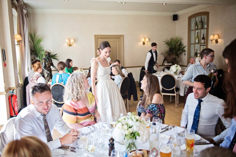 Natural Storytelling portrait of Bride chatting to wedding guests at Hotel du Vin, Winchester. Photo by Blooming Photography.