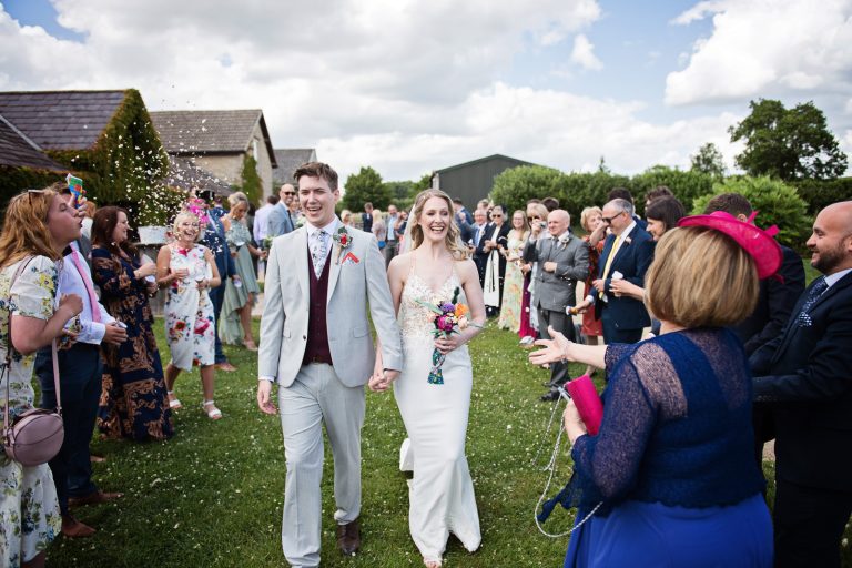 Documentary style wedding photography of guests throwing confetti at the bride and groom..