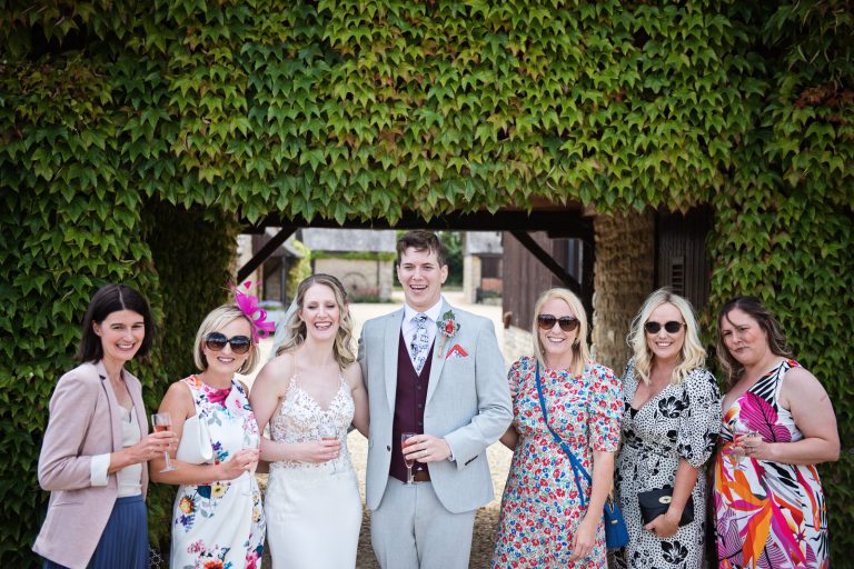 Bride and groom pose with their friends for a photo.