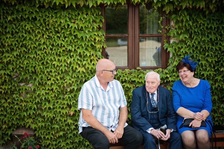 Relaxed wedding photography - guests chatting.