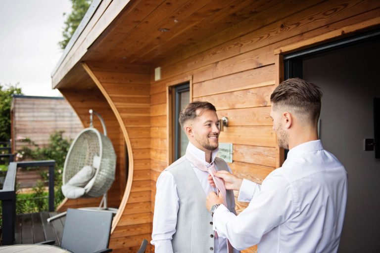 Candid photograph of groomsmen getting ready at Kingscote Barn, Gloucestershire.