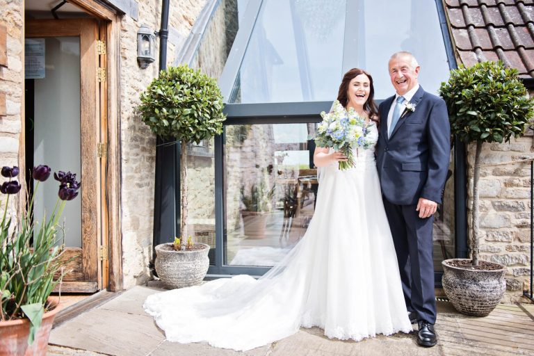 Bride and father of the bride laughing at Kingscote Barn