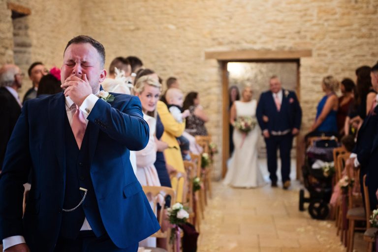 Candid moment of emotional groom captured by Blooming Photography taken at Kingscote Barn