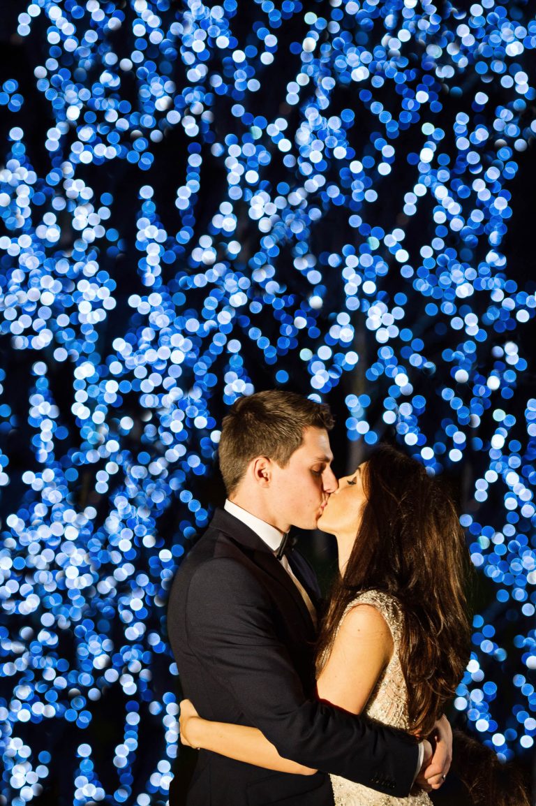 Bride and groom with light wall at Kingscote Barn by Blooming Photography