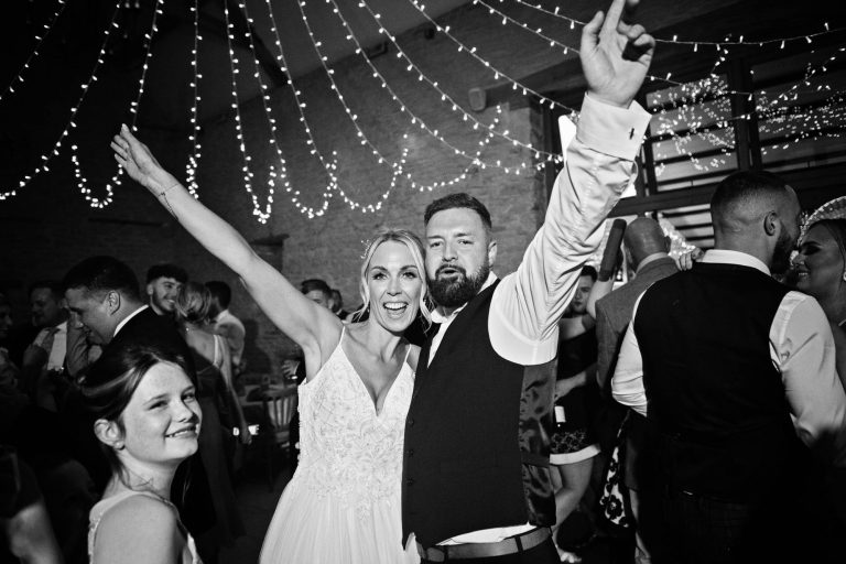Bride and groom celebrate after doing the first dance at Kingscote Barn