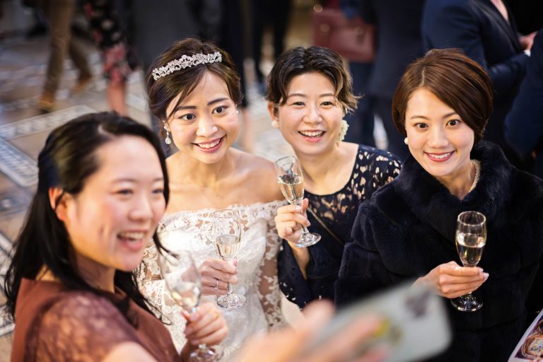 Bride and bridesmaids do a selfie, candid photograph by Blooming Photography.