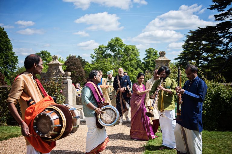 Musicians get ready for the Indian ceremony (outdoors), at North Mymms Park, candidly photographed by Blooming Photography.