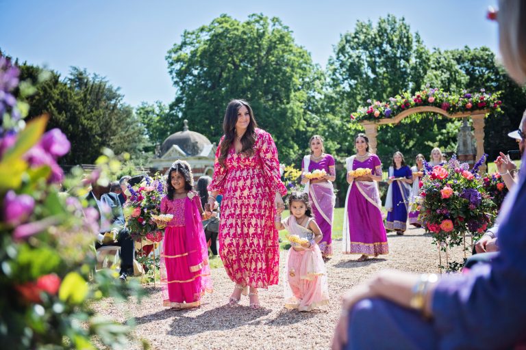 Bride's family entrance at North Mymms Park, candidly photographed by Blooming Photography. Colourful.