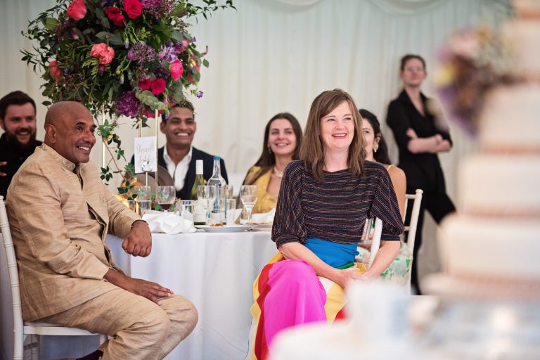 Family listen, smiling to the grooms speech. Photographed at North Mymms Park, by Blooming Photography.