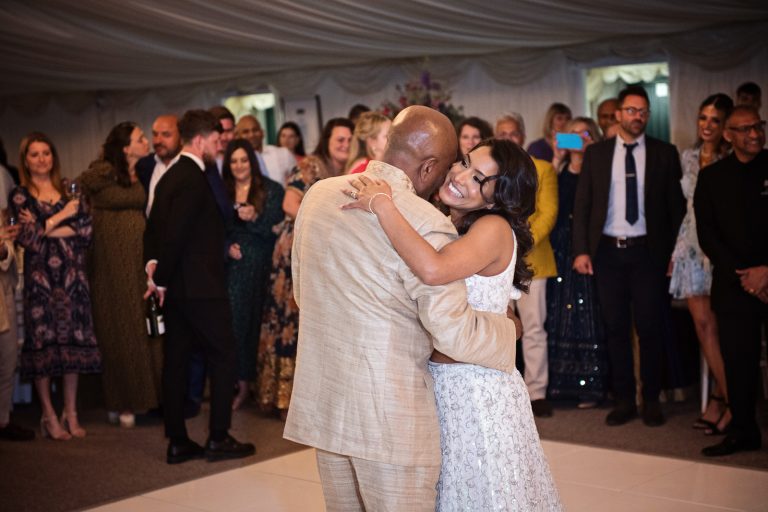 Bride hugs her dad as they do a father daughter first dance. Photographed at North Mymms Park, by Blooming Photography.