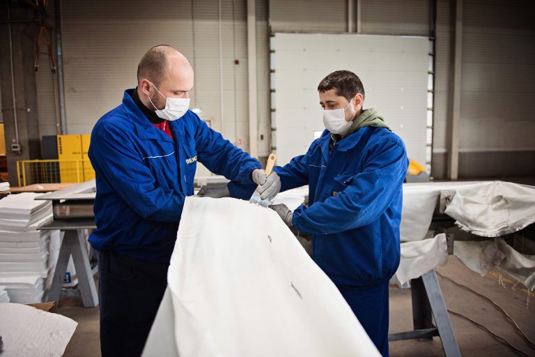 Two workers creating an expansion joint in a manufacturing factory in Romania.