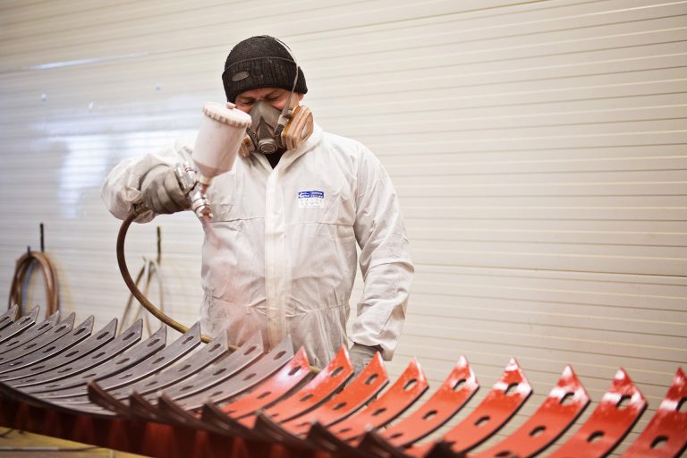 A worker paint spraying an expansion joint in a engineering factory in Romania.