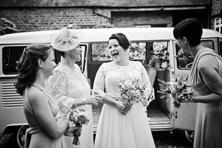 Storytelling documentary b&w photo of bride and her team laughing.