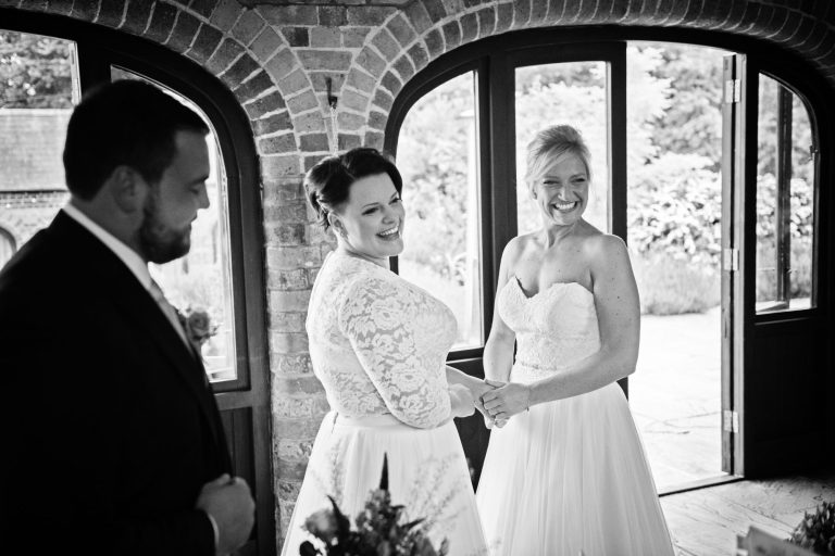 Bride and bride hold hands after being announced wife and wife.
