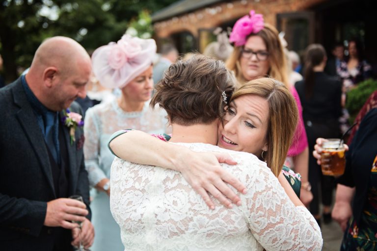 Storytelling photograph of guests hugging the bride