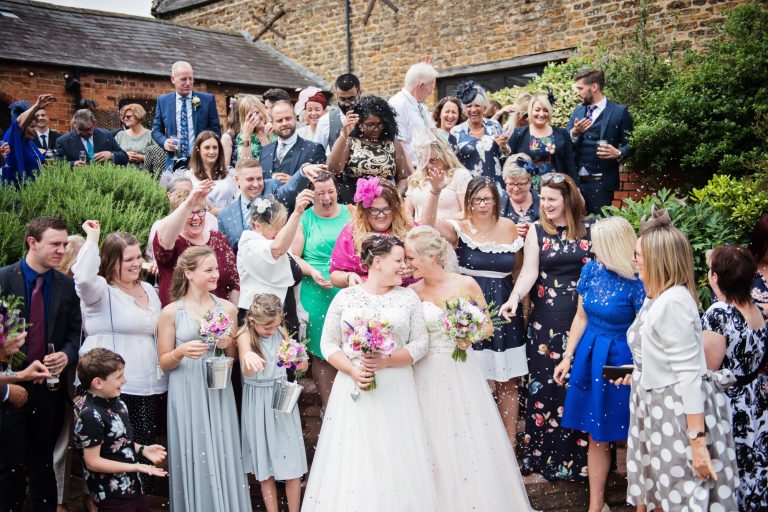 Bride and bride celebrate with their guests with confetti at Dodmoor House.