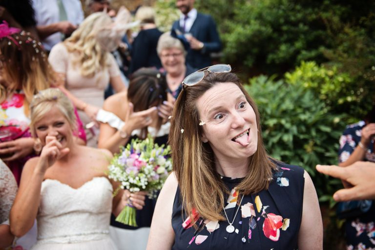 Candid photograph of wedding guests pulling funny faces.