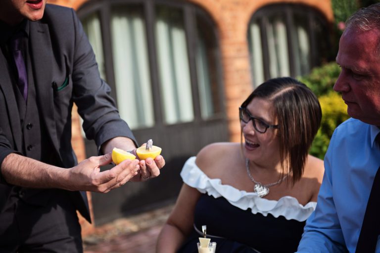 Documentary photo of wedding guests getting wowed by the magician's magic trick
