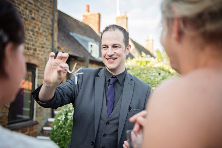 Magician bends forks with the bride and bride watching.