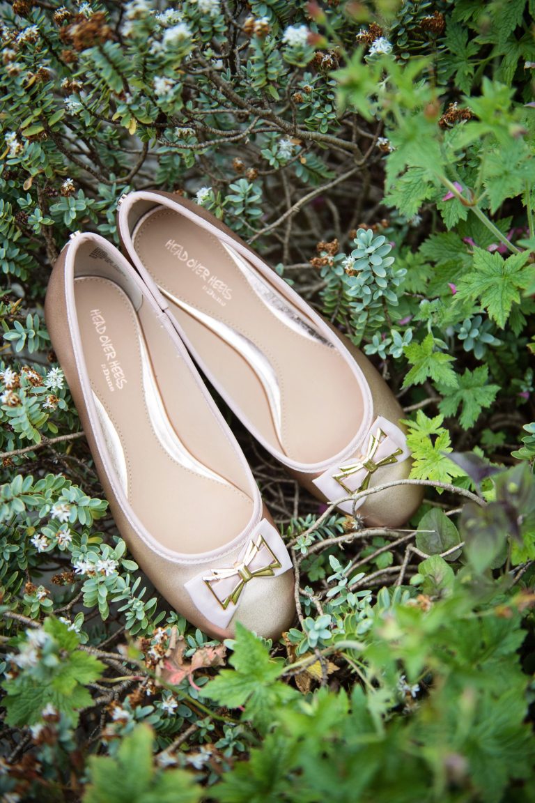 Wedding shoes in the middle of a hebé flower border.