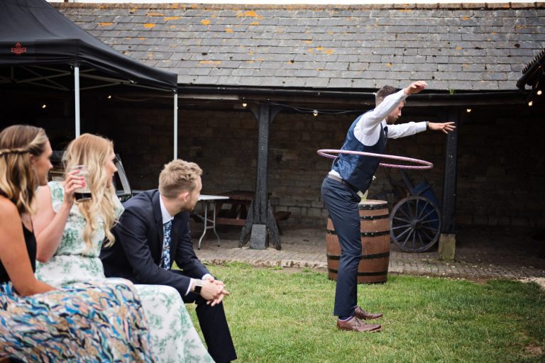 Candid wedding photo of guest doing the hoola hoop at Overbarn, Gloucester