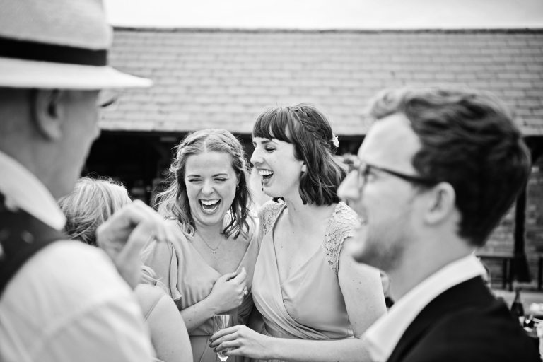 B&W Candid wedding photo of people laughing at Overbarn, Gloucester